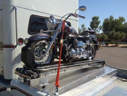 Picture Of Motorcycle Loader behind the cab of a Freightliner RV Hauler